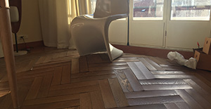 Un parquet déformé par un dégât des eaux, créant une ambiance de désolation.