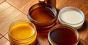 Des types de liquides colorés dans des bocaux en verre, illustrant la diversité des finitions possibles sur le parquet.