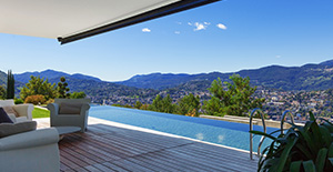 Terrasse en bois donnant sur une piscine et vue sur les montagnes