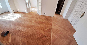 Intérieur d'une pièce avec un sol en bois raccordé, connectant le couloir à l'espace principal.