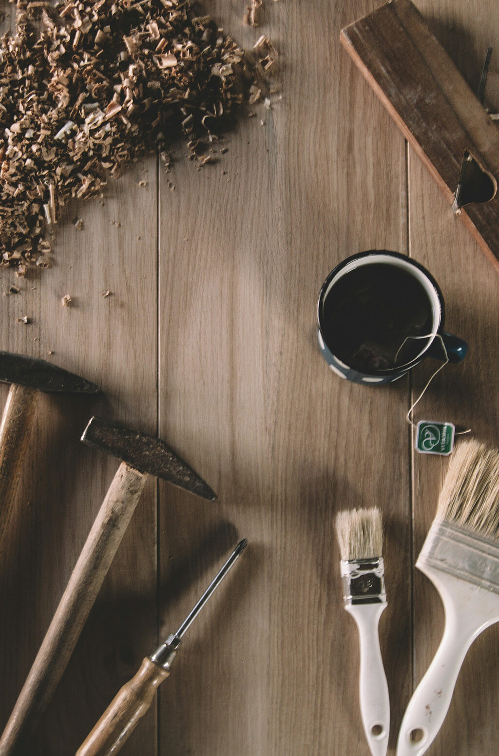 Image poétique sur fond en bois avec de la sciure de bois, des outils d'artisan et une tasse de thé