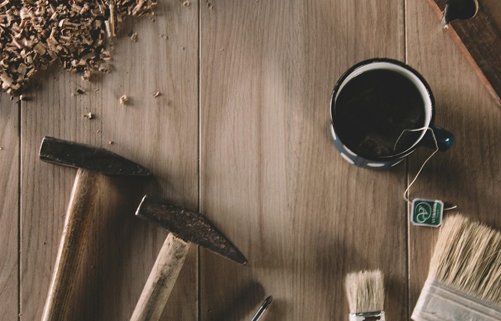 Image poétique sur fond en bois avec de la sciure de bois, des outils d'artisan et une tasse de thé