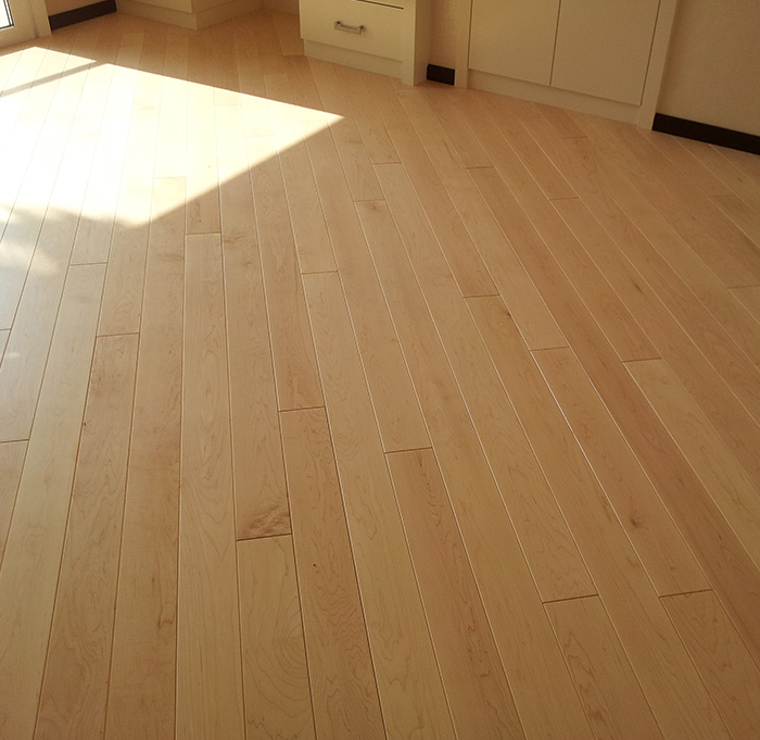 Un parquet en bois dans une pièce, éclairée par la lumière naturelle d'une fenêtre, offrant une atmosphère agréable.