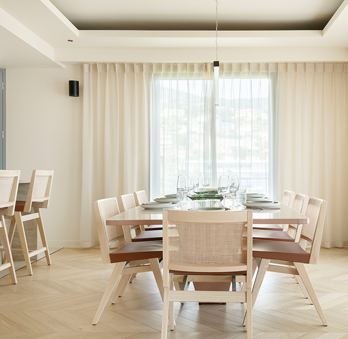 Salle à manger avec une table élégante et des chaises confortables, prête pour un repas convivial sur un parquet aux couleurs douces et apaisantes.