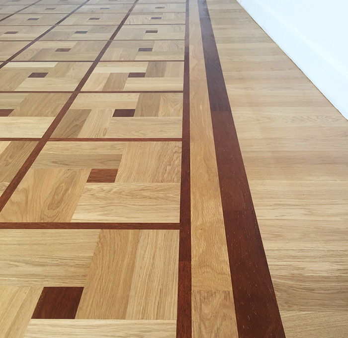 Un parquet en bois naturel avec un motif damier, ajoutant du caractère à l'espace.