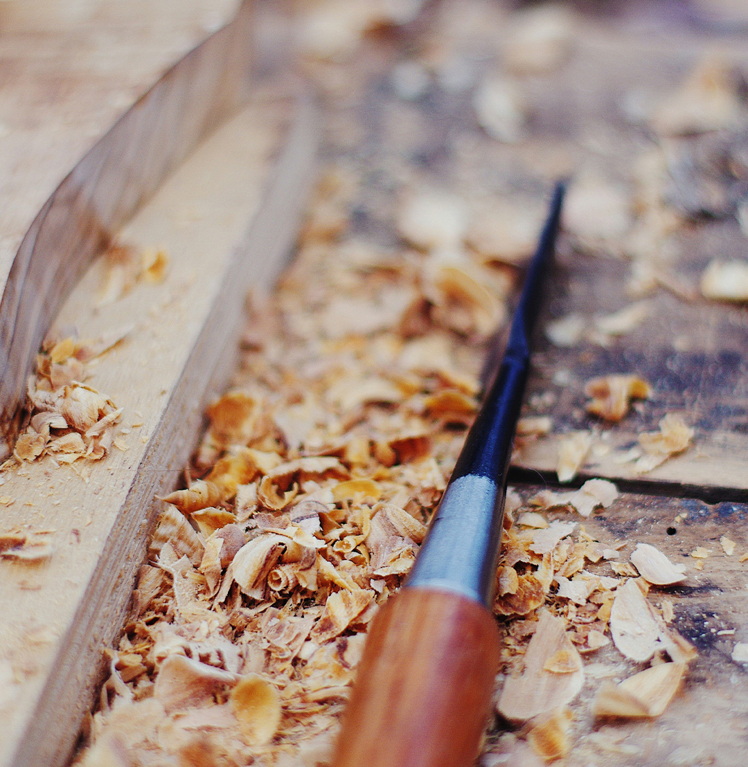 Outil de travail du bois sur une table, avec des copeaux de bois dispersés autour.