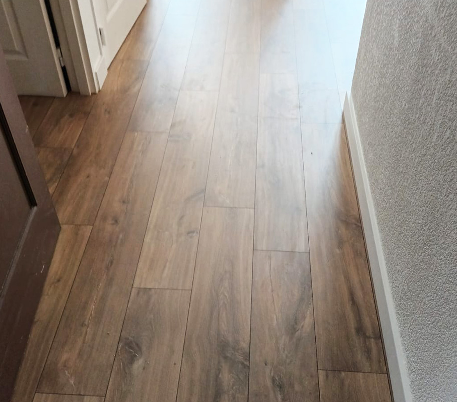 Un couloir en bois avec un sol en parquet et une porte, ajoutant du caractère à l'intérieur.