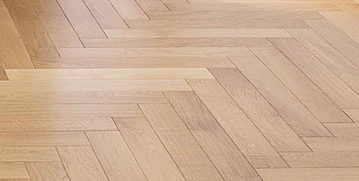 Gros plan sur un motif de pose de parquet : à bâtons rompus
