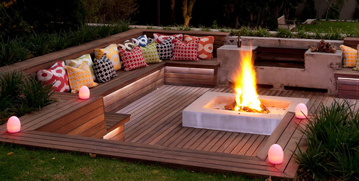 Décoration terrasse extérieure en bois ou composite avec brasero, au crépuscule