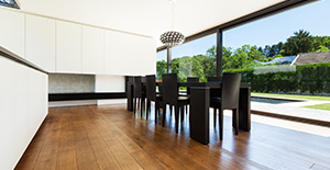 Salle à manger moderne avec parquet chaleureux et vue sur la piscine et le jardin