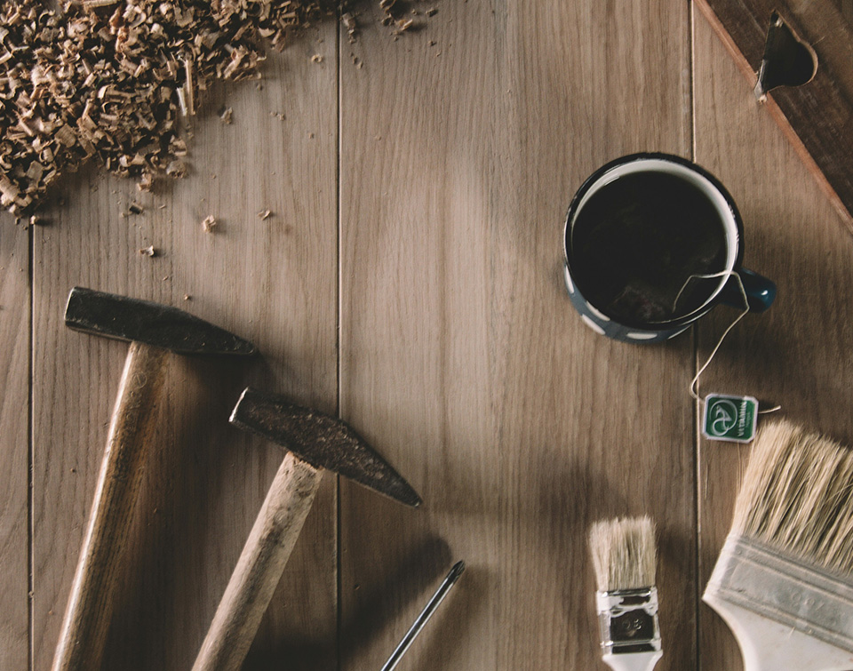 Image poétique sur fond en bois avec de la sciure de bois, des outils d'artisan et une tasse de thé